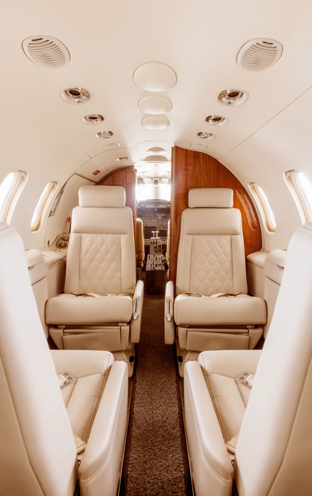 Interior de la cabina de un jet privado de SAE con asientos de piel en tono claro