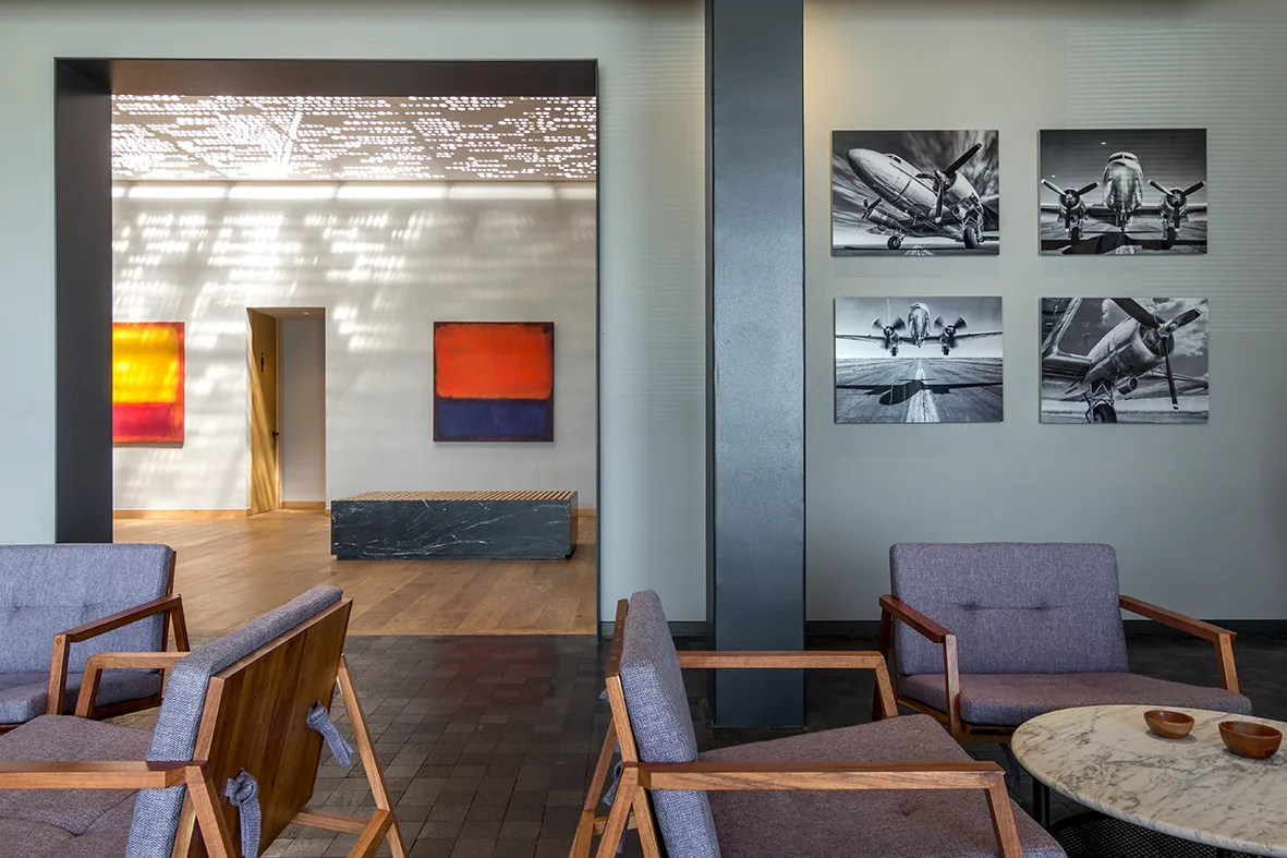 Sala de espera del FBO de SAE con sillones y fotografías de aviación